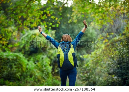Active healthy woman hiking in beautiful forest. Portrait of happy  young woman resting of forest clearing during hike holidays.