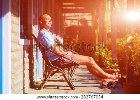 man relaxed and enjoy in chair at the sunny morning in patio