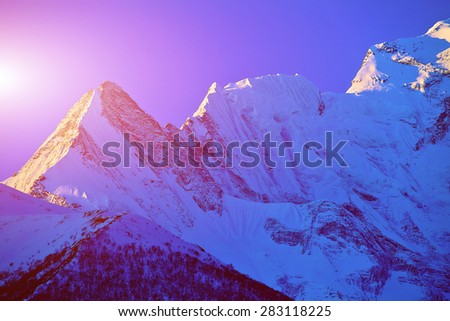 beautifull cloudy sunrise in the mountains with snow ridge. Himalaya, Nepal. Trek around Annapurna mount