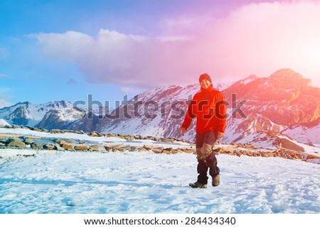 hiker at the top of a pass meeting the sunrise in the mountains