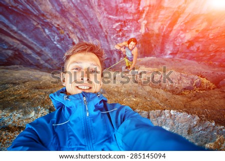 young  man make selfie on the rock background