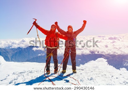 hikers at the top of a pass with backpacks meeting the sunrise in the mountains. Mount Kazbek, Georgia, Caucasus.