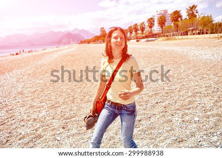 happy woman running on the beach at sunrise against the sun