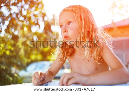 Cheerful little girl with sketch pen drawing in outdoor