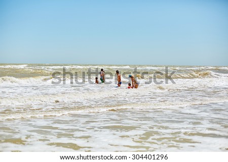 family swimming in the big  sea wave