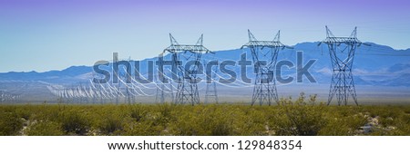 Power lines across the high voltage towers across the desert landscape