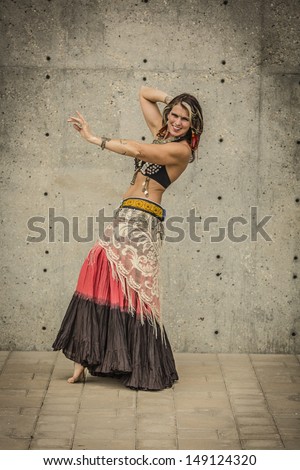 Tribal fusion belly dance costume with 25 yard skirt, fringe and kuchi belt with coin and shell bra, typically accessorized with metal earrings, choker type necklace, multiple arm bands and rings.