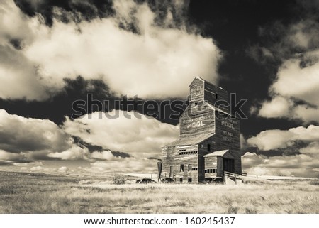 An old vintage wooden grain elevator in the ghost town of Bents, Saskatchewan.  Processed with an infrared filter.