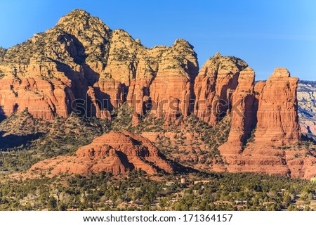 The red rocks found in the Sedona, Arizona area. The red sandstone formations appear to glow in brilliant orange and red when illuminated by the rising or setting sun.