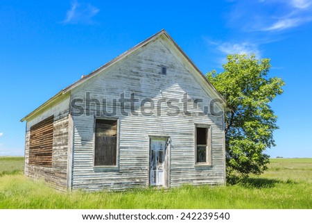 An old abandoned farm house with weathered wood and paint.