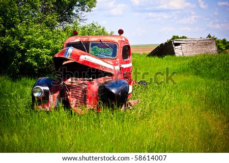 Old rusty red farm truck fading in time.