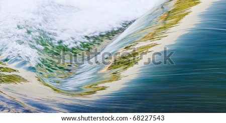 Water flowing down a waterfall with the illuminated reflected in the waves
