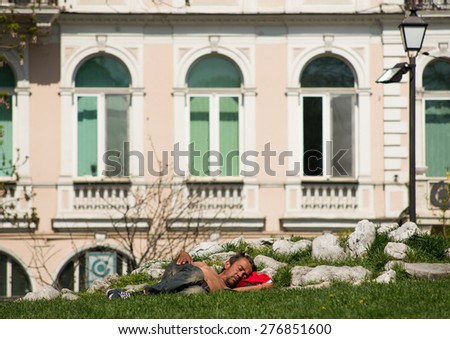A half-dressed homeless man is sleeping on the grass in the City garden park in Sofia, Bulgaria, April 27, 2015.  Poverty is still big issue in Bulgaria even after the country joined the EU.