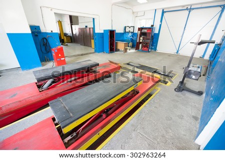 Empty garage workshop with car stand and special equipment for repairs at car service center, \