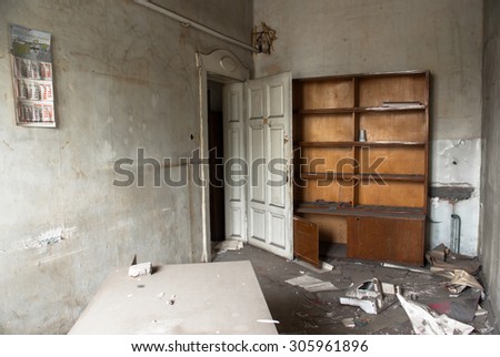 Destroyed desk and book shelf in the principal\'s office in an old school building Sofia, Bulgaria, May 12, 2014. Some of the doors and windows had been wrecked. Thick layer of dust ??? all over.