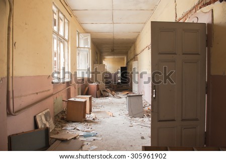 Abandoned corridor and destroyed desks and lockers in an old school building Sofia, Bulgaria, May 12, 2014. Some of the doors and windows had been wrecked. Thick layer of dust is all over the place.