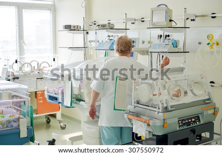 Nurse is checking the vital signs of a newborn sleeping baby in an incubator in the Obstetrics and Gynecology Hospital 
