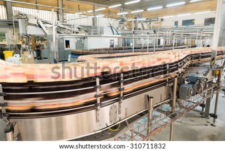 Blurred bottles filled with beer on a transport machine\'s conveyor belt during production process in Molson Coors Kamenitza beer brewery, April 28, 2015, near the city of Haskovo, Bulgaria.