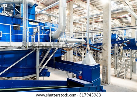 Sofia, Bulgaria - Pipes and conveyor belt machinery for processing recycled organic waste in a recycling waste to energy and composting factory.
