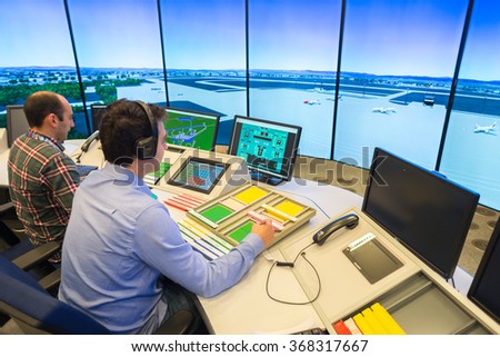 Air Traffic Controllers in air traffic simulator center with monitors and radar in the\