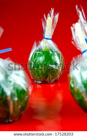 Toffee apples isolated against a red background