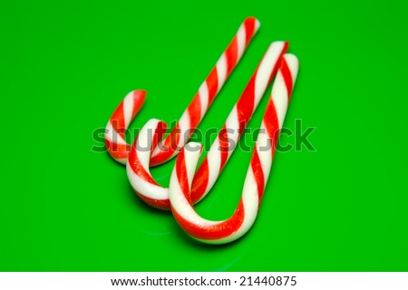 Christmas candy canes isolated against a green background