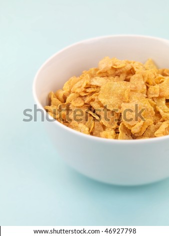 A bowl of breakfast cereal isolated on a pale blue tablecloth