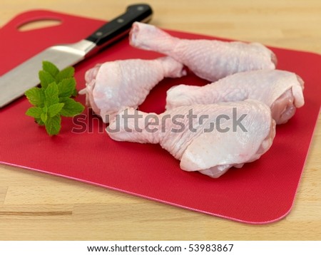 Raw chicken drumsticks on a kitchen bench