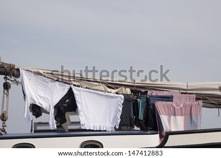 Washed clothes pieces hang to dry on board a boat
