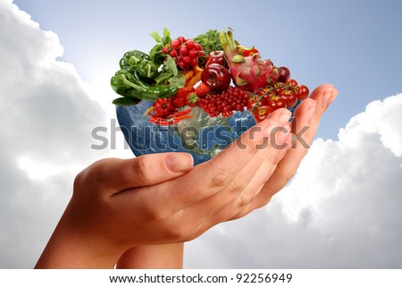 Two hands holding fruitful earth against a blue cloudy sky
