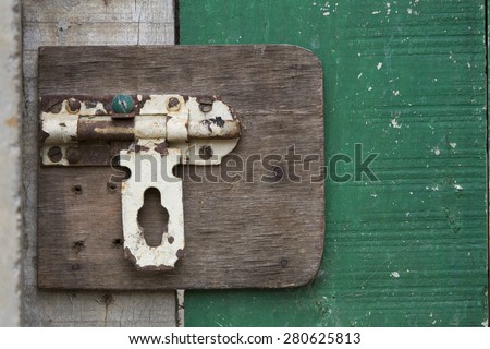 Closeup of old vintage door latch on green door
