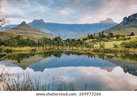 Dramatic mountains reflected in a still lake at sunset in the Royal Natal National Park, Kwazulu-Natal, South Africa