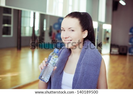 Young woman at the gym drinks water