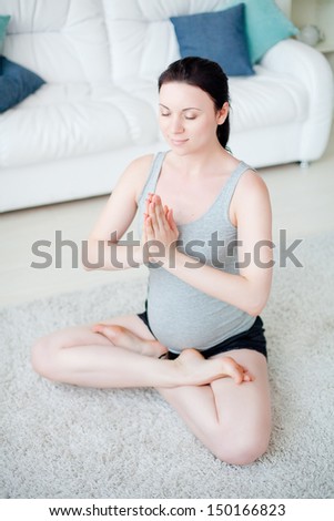 Young pregnant woman do yoga indoors