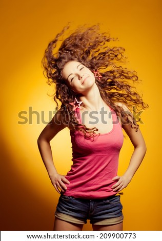 Sexy happy woman dancing excited on yellow background