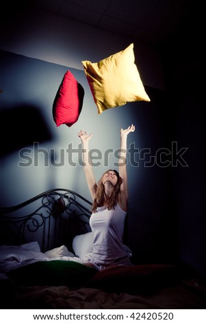 The girl throws up pillows