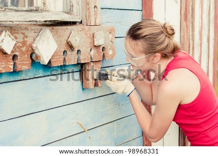 Portrait of smiling young woman making cosmetic alterations of house