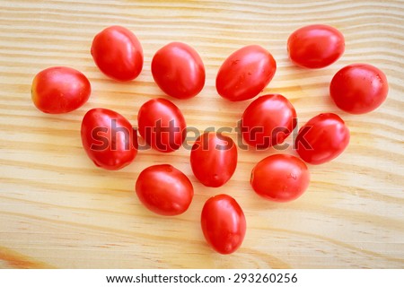 Tomatoes place on wood like heart pattern