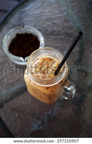 Ice coffee and coffee ground in a ashtray on table