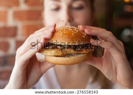 Beauty woman in cafe eating some burger