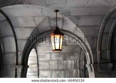 Old-fashioned lantern hanging down from the white brick dome-like ceiling