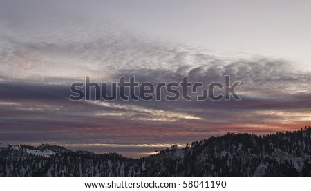 sun setting on a snowy ski resort in big bear on the san bernardino mountains,with the night lights turning on for night skiing,california,winter 2009.