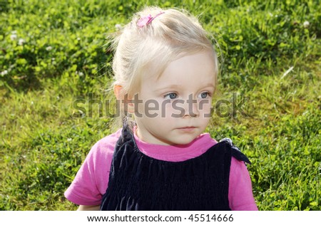 Portrait of pensive girl sitting on the grass