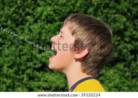 boy splattering water out of his mouth