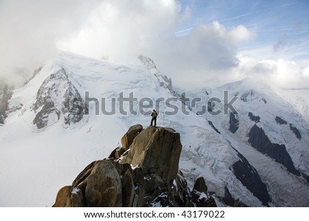 Wide angle view of high snowy mountains with man stood