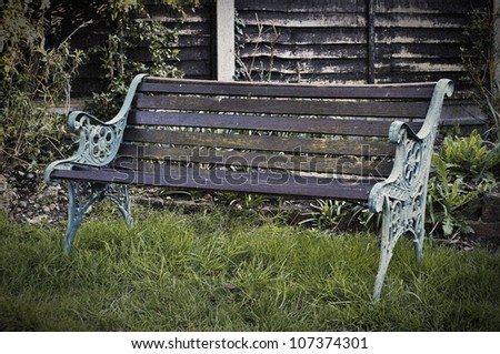 Vintage bench in a garden, retro style picture with film grain and vignette