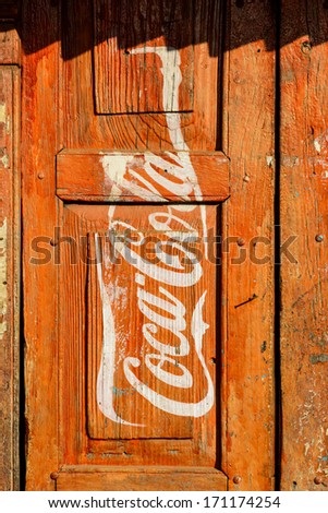 Kathmandu, Nepal - Circa January 2014: Vintage Coca-Cola Advertisement Painted On A Red Wooden Door.