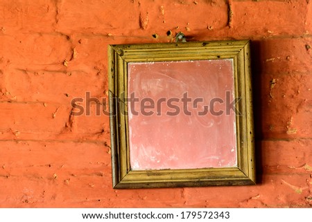 Square mirror on a brick wall
