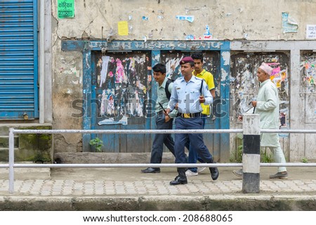 KATHMANDU, NEPAL - AUGUST 3, 2014: Police officer and pedestrians on the way Indian Prime Minister Narendra Modi will take when he arrives in Kathmandu on a 2-day official Nepal visit.