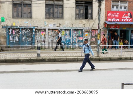 KATHMANDU, NEPAL - AUGUST 3, 2014: Police officer and pedestrians on the way Indian Prime Minister Narendra Modi will take when he arrives in Kathmandu on a 2-day official Nepal visit.